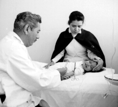 Médico y enfermera vacunan a niña