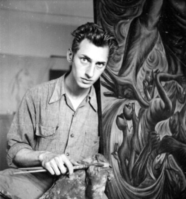 Arnold Belkin recragado junto a pintura mural, retrato