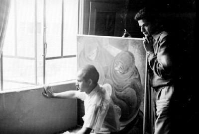 Satish con un hombre miran por una ventana