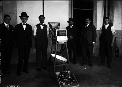 Abraham Ferriz con otros hombres junto a uno de sus inventos, retrato de grupo