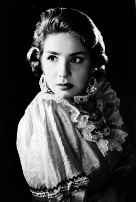 Rosita Quintana, de perfil con rostro al frente, fondo oscuro, reproducción fotográfica