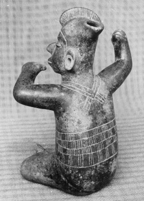Figurilla antropomorfa sedente decorada con incisiones, vista posterior