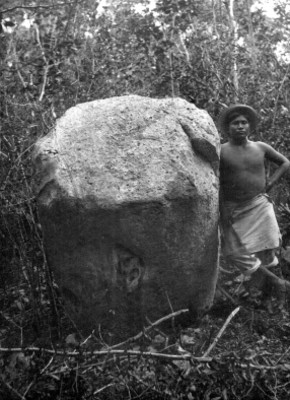 Hombre junto a piedra con relieve