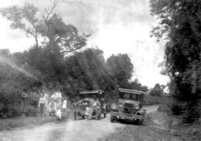 Familia de pie frente a un automóvil, retrato de grupo