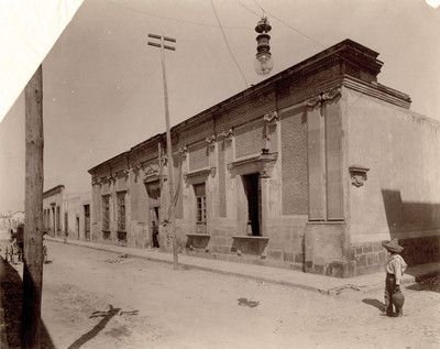 Niño camina frente a casa de estilo colonial