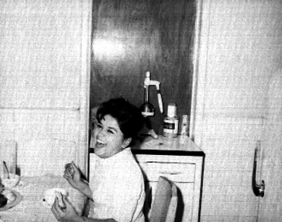 Mujer, familiar de los Gordoa, sonriendo sentada a la mesa