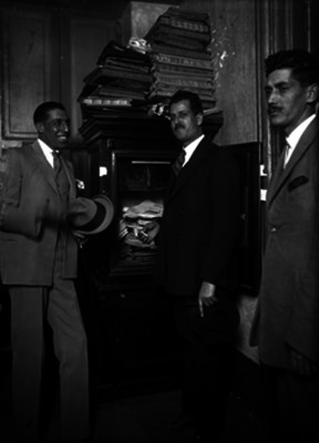 José María Gutiérrez conversando con dos hombres en una oficina, retrato