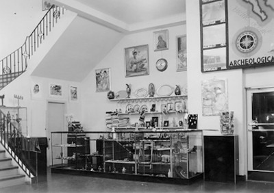 Vista de vitrina con artículos de venta, pinturas y mapa de zonas arqueológicas