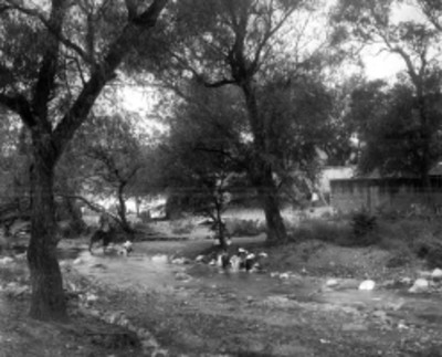 Mujeres lavan ropa a orillas de un río