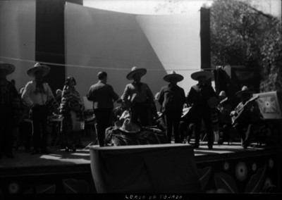 Miguel Lerdo de Tejada dirige la Orquesta Típica Mexicana, mientras unos cantantes interpretan una melodia, durante un festival cultural