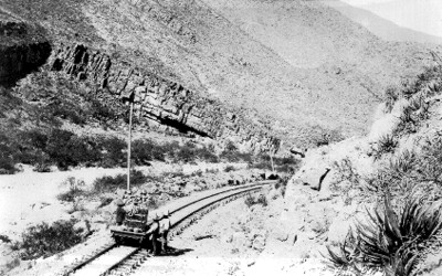 Hombres frente a un vagón de tren, en el cañon de Saltillo