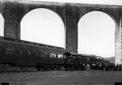 Ferrocarril y pasajeros bajo el acueducto de Querétaro