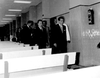 Adolfo López Mateos, Benito Coquet y médicos recorriendo sala de espera de la clínica del IMSS Unidad Revolución durante su inauguración
