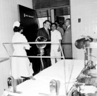 Adolfo López Mateos y funcionarios caminando entre un mitin durante la inauguración de instalaciones del IMSS