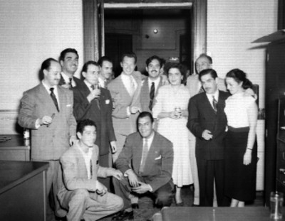 Empresarios y empleados celebrando el aniversario de la revista Hoy en una oficina, retrato de grupo