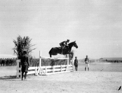 Militar montado a caballo saltando obstáculo durante practicas