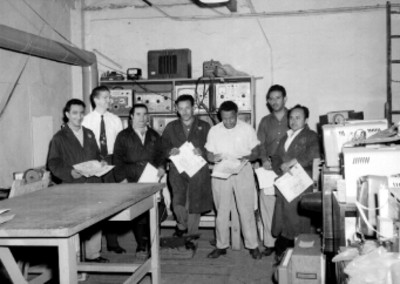 Empleados con diploma Cipres en un taller de la General Electric, retrato de grupo
