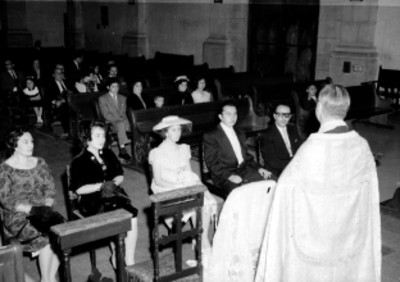 Quinceañera y familiares ante un saerdote, mientras oficia la ceremonia religiosa