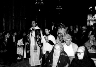 Novios tras un sacerdote dirigiendose al altar, durante su boda religiosa