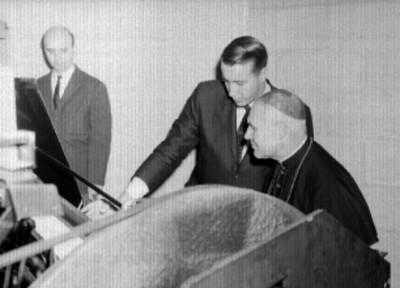 Luigi Raimondi con otro individuo observan una máquina de bolos durante la inauguración de un boliche