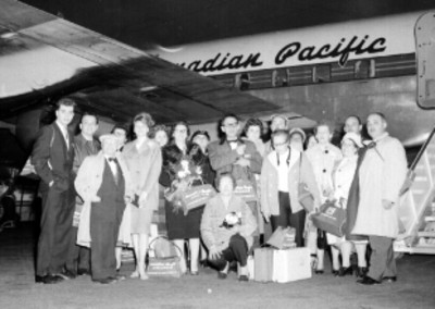Pasajeros con equipaje junto a un avión de la linea Canadian Pacific, en el aeropuerto, retrato de grupo