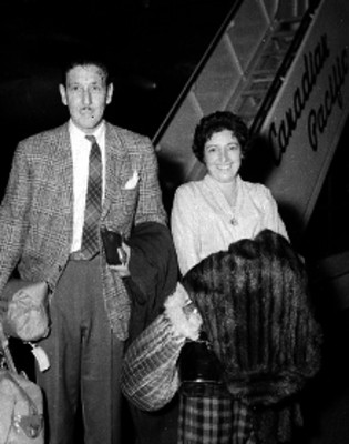Pareja de pasajeros frente a un avión de la Canadian Pacific, retrato