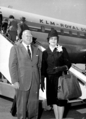 Pareja de pasajeros frente a un avión de la KLM, retrato