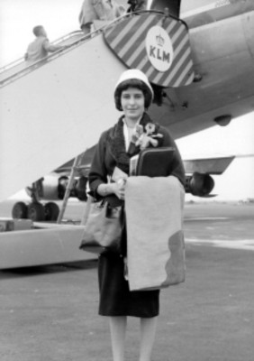 Mujer elegante frente a un avión de la KLM, retrato