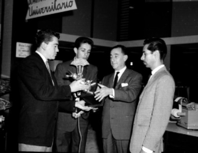 Locutores de Radio Mil entregando trofeo a empresarios de High Life en una tienda