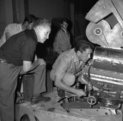 Gabriel Figueroa y trabajadores inspeccionando una cámara cinematográfica en un foro