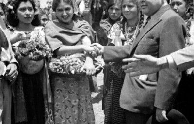Funcionario saludando a mujeres con trajes típicos durante el festival de la Flor más bella del ejido de Xochimilco