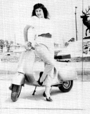 Actríz sobre una motocicleta posando junto a una fuente, retrato
