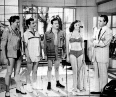 Actores en traje de baño conversando con otro en una habitación, escena de película