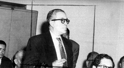 Empresario cinematográfico haciendo uso de la palabra durante una reunión en un salón