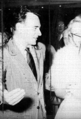 Pareja de artístas conversando tomados del brazo durante un evento en un salón