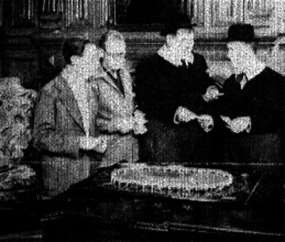 Los actores norteamericanos El Gordo y El Flaco observando una maqueta con otros individuos, escena de película