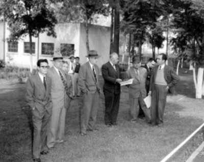 Gliberto Flores Muñoz, funcionarios y ganaderos conversando en el patio de un establo