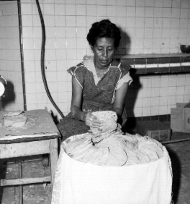 Mujer acomodando tortillas en una canasta