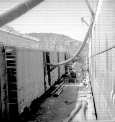 Embarque de trigo a un barco desde furgones en el puerto de Guaymas