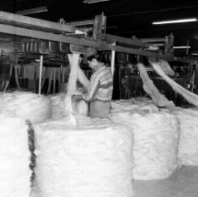 Obreros mamiobrando hiladoras en una fábrica de costales de CONASUPO