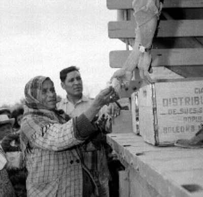 Mujer de clase campesina comprando viveres en una tienda móvil de la CONASUPO