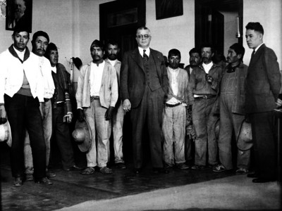 Juan José Méndez reunido con hombres de clase baja, en su oficina, durante una audiencia, retrato de grupo