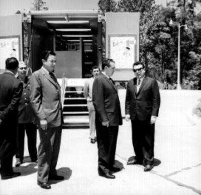 Adolfo López Mateos, Roberto Amorós y comitiva, observan las nuevas tiendas móviles adaptadas por la CEIMSA