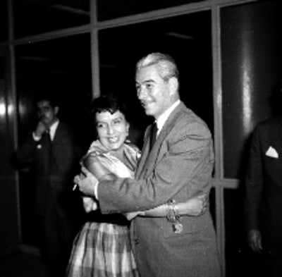 Maria Cristina Salmorán observando a mujeres a travéz de un cristal durante su recepción en el aeropuerto