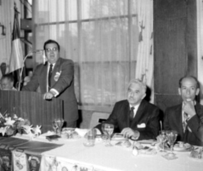 Miembro del Club Rotario pronuncia discurso en presencia de Julio Santos
