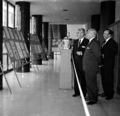 Salomón González Blanco con Julio Santos Coy y funcionarios observan una exposición de carteles sobre seguridad laboral