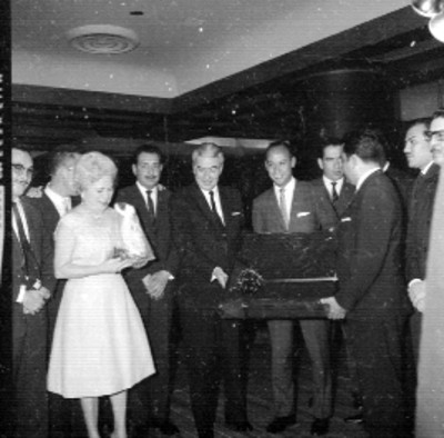 Salomón González Blanco y esposa observando charola obsequiada por funcionarios durante una cena en el Hotel Presidente