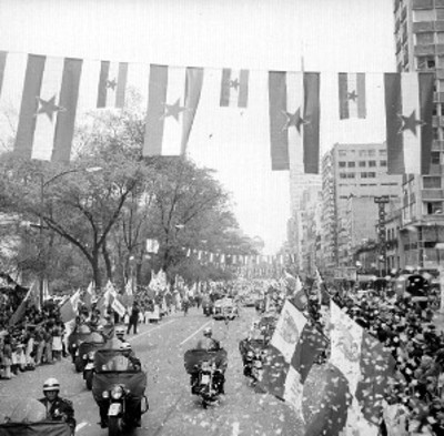 Adolfo López Mateos y Broz Tito saluda a la gente al pasar junto al edificio de la torre Latinoamericana