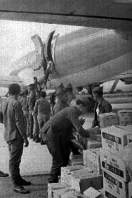 Militares bajan cajas de un avión