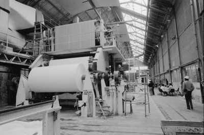 Trabajadores en interior de la fábrica San Rafael junto a bobinadora de papel